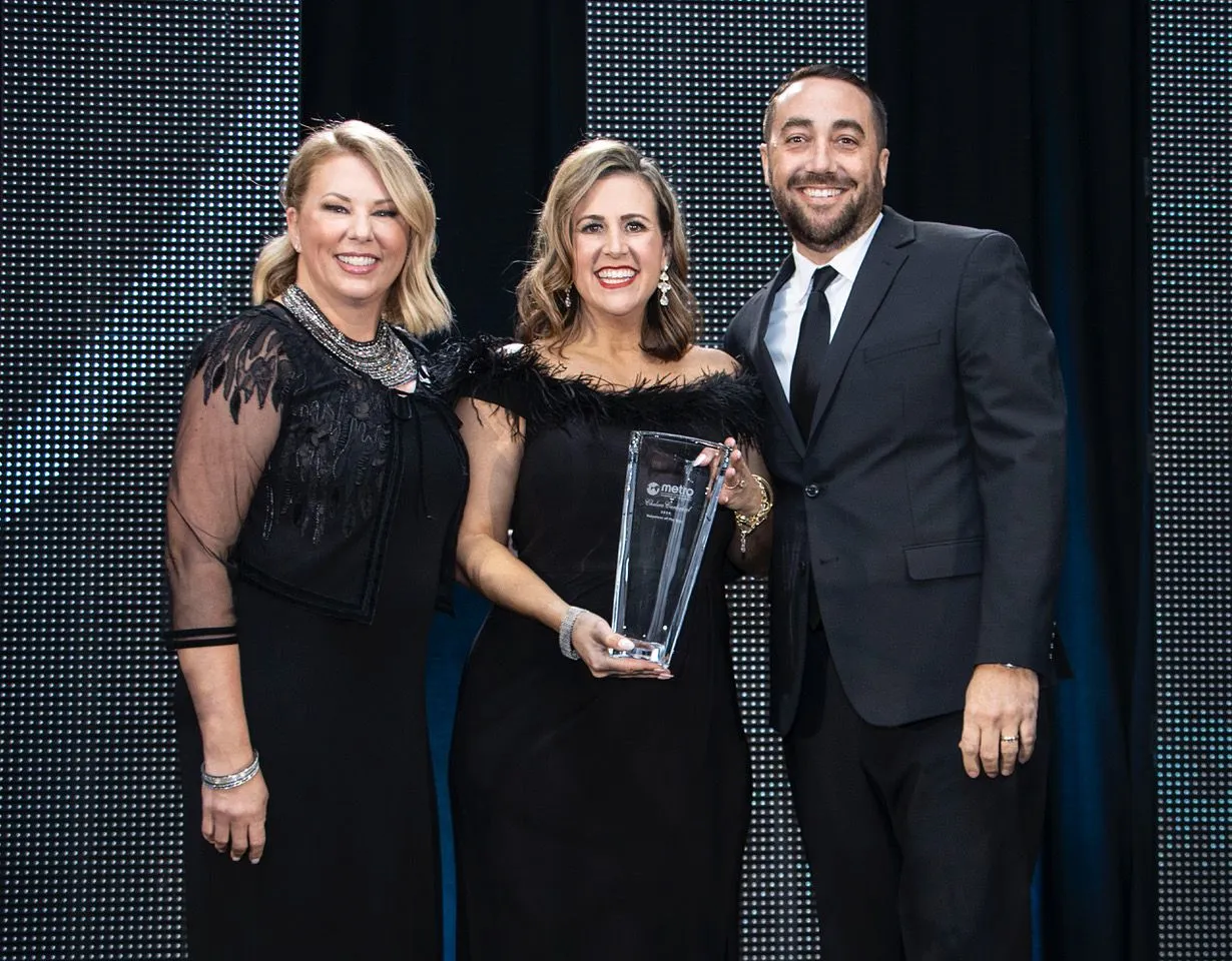 3 people holding an award